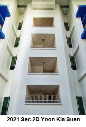 Symmetrical view of a white apartment building with stacked balconies and blue accents.
